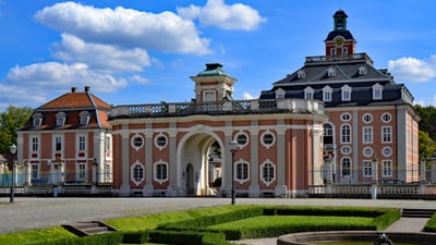 schloss-bruchsal.jpg Barockschloss mit prachtvollen Gärten und blauem Himmel.