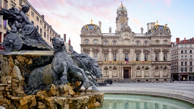 twerenbold_93895.jpg Historisches Gebäude mit Brunnen und Skulpturen im Vordergrund.