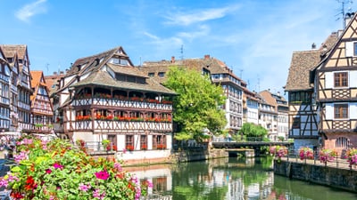 strassburg.jpg Malebene Fachwerkhäuser an einem Kanal mit Blumen und Brücke.