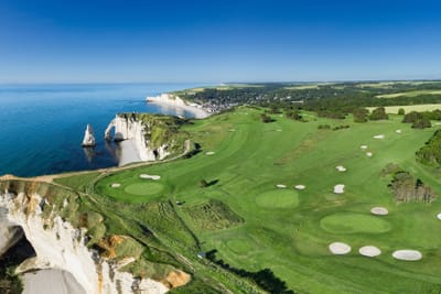 Panoramablick auf Golfplatz an Küstenklippen mit Meer.