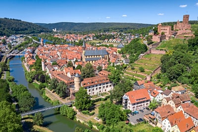 wertheim.jpg Luftbild einer Stadt mit Fluss, Burgruine und roten Dächern.