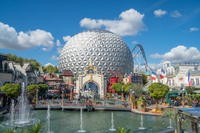 per-schiff-zum-europa-park-6.jpg Silberne Kugel im Freizeitpark mit Springbrunnen und Besucherbereich.