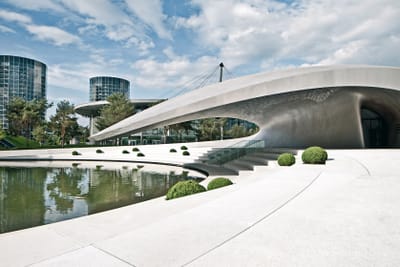 zwischen-lifestyle-und-autogeschichte-in-der-autostadt-wolfs.jpg Moderne Architektur mit gewölbtem Gebäude und Teich im Freien.