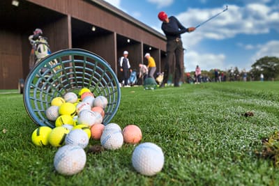 grand-golf-cruise-basel-amsterdam-6.jpg Golfschläge auf einer Driving Range mit verstreuten Golfbällen.