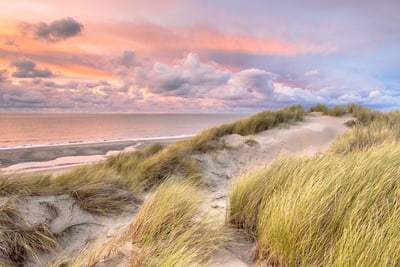 Sanddünen am Strand bei Sonnenuntergang.