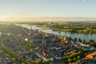 Panorama einer Stadt mit Fluss und Kirche im Vordergrund.