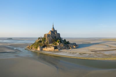 Luftaufnahme einer mittelalterlichen Insel mit umliegendem Sand und Wasser bei Ebbe.
