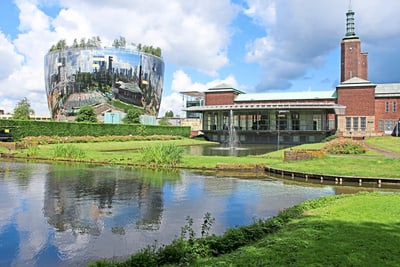 Spiegelndes kugelförmiges Gebäude mit modernem Design bei sonnigem Himmel.