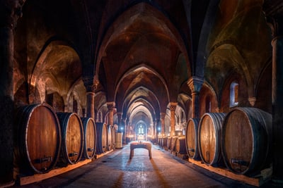 wein-geschichten-und-stille-vereint-im-hospitalkeller-von-kl.jpg Historischer Weinkeller mit Holzfässern und gotischen Bögen.