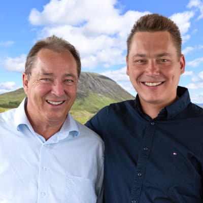 die-cruise-fuer-whisky-lovers-1.jpg Zwei Männer lächeln in einer grünen Hügellandschaft.