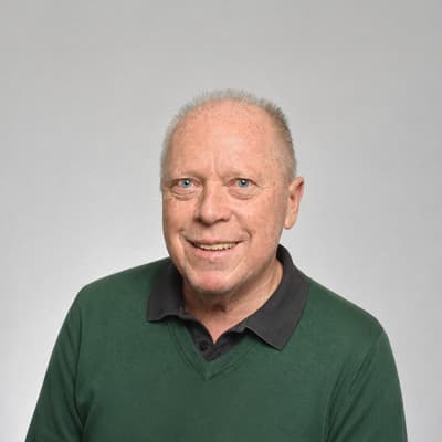 donau-digital-von-ki-bis-cyber-security-1.png Älterer Mann in grünem Pullover vor grauem Hintergrund.