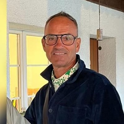 grand-golf-cruise-basel-amsterdam-1.jpg Mann mit Brille in einem Raum mit Fenster.