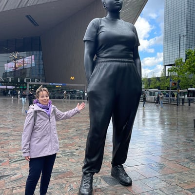 kunst-und-architektur-in-flandern-1.jpg Person steht neben grosser Statue auf Platz vor modernem Gebäude.