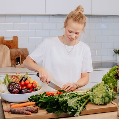 die-donau-inspirierend-gesund-und-fit-1.jpg Frau schneidet Gemüse in moderner Küche.