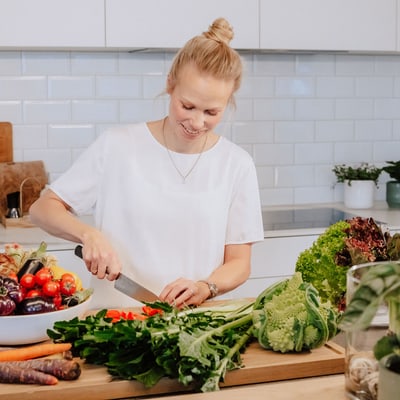 die-donau-inspirierend-gesund-und-fit-1.jpg Frau schneidet Gemüse in moderner Küche.