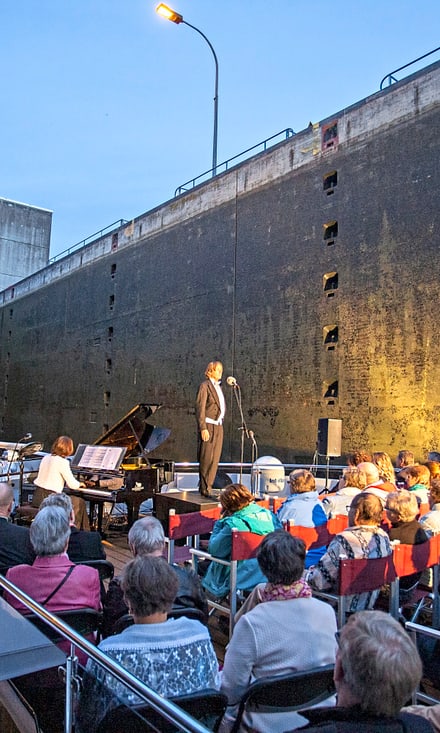 Konzert auf einem Boot in einer Schleusenanlage bei Abenddämmerung.
