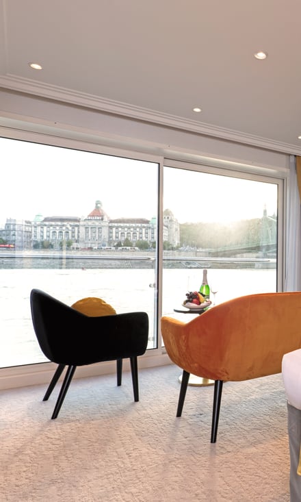 Geräumige Suite auf der Excellence Crown mit Doppelbett, Sitzecke und Panoramafenster mit Flussblick.
