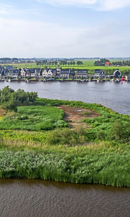 Aerial of river, grasslands and waterfront houses, Sneek, Friesland, Netherlands