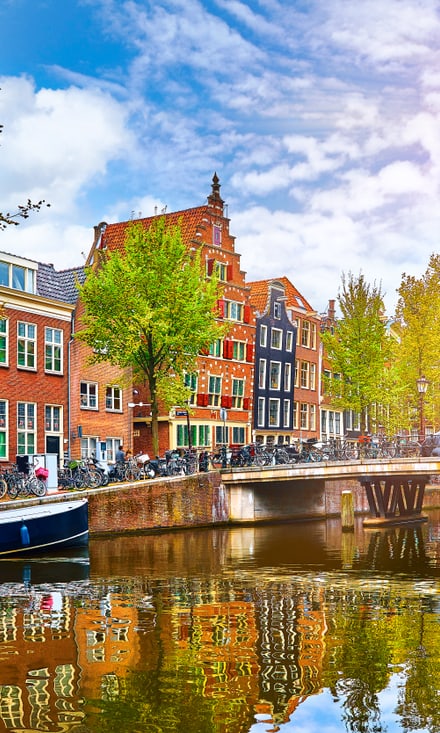 Farbenfrohe Häuser und Kanal in Amsterdam bei Sonnenschein.