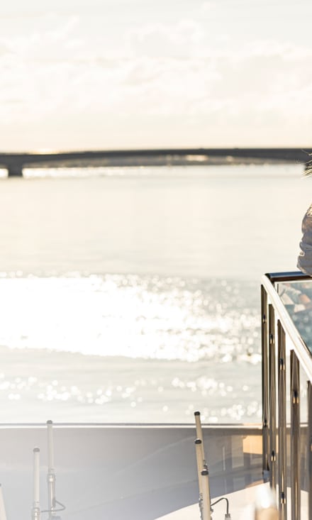 Frau geniesst den Blick vom Boot aufs Wasser.