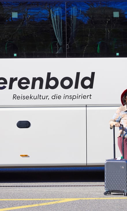 Zwei Gäste machen ein Selfie vor dem Reisebus