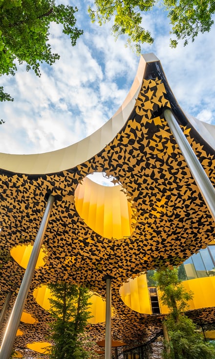 Modernes Kulturgebäude Magyar Zene Háza mit geschwungenem Dach und gelb-schwarzen Mustern im Stadtwäldchen Budapest.