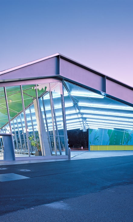 Moderne Architektur eines beleuchteten Gebäudes bei Abenddämmerung.
