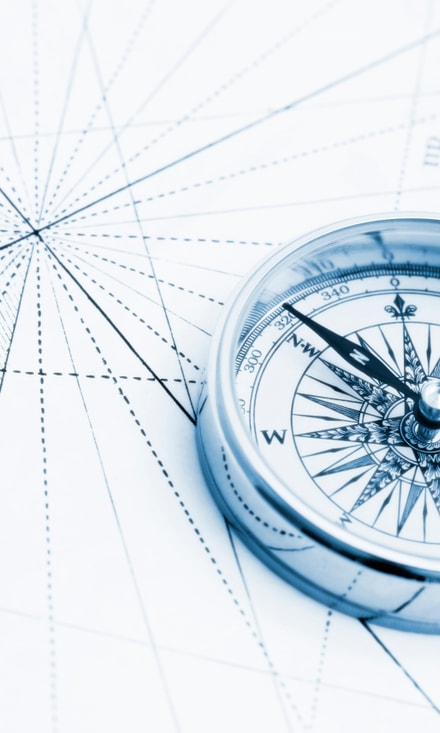 Compass on vintage map with blue tone and high key lighting