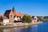 Historische Gebäude am Flussufer mit blauem Himmel.