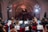Orchester spielt in beleuchtetem Konzertsaal vor Publikum.