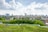 Stadtpanorama mit grüner Dachterrasse und Wolken am Himmel.