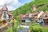 Malerisches Dorf mit Fachwerkhäusern entlang eines Baches.