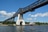 Grosse Eisenbahnbrücke über einen Fluss mit blauen Himmel und einigen Wolken.