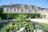 Historisches Steinhaus mit Garten voller Blumen.