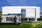 Moderne weisse Fassade eines grossen Gebäudes mit Glasfront.