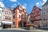 Historische Fachwerkhäuser mit Brunnen auf einem Platz.