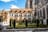 Garten vor alter Kathedrale mit Bäumen und gotischen Bögen.