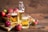 Frische Äpfel und Apfelwein in Gläsern auf Holztisch.