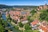 Luftbild einer Stadt mit Fluss, Burgruine und roten Dächern.