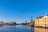 Wasserblick auf Gebäude und Schiff unter blauem Himmel.
