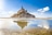 Le Mont-Saint-Michel bei Ebbe mit Spiegelung im Wasser.