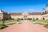 Historisches Schloss mit Garten und blauem Himmel.