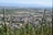 Blick auf eine Stadt neben Weinbergen mit Bergen im Hintergrund.