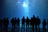 Silhouetten von Menschen vor Aquariumglas mit schwimmenden Fischen.