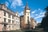 Historisches Schloss mit Türmen und dekorativer Fassade unter blauem Himmel.