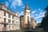 Historisches Schloss mit Türmen und dekorativer Fassade unter blauem Himmel.