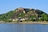Festung auf grünem Hügel am Flussufer.