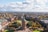Luftaufnahme eines historischen Turms in einem Stadtzentrum mit umliegenden Parks und Gebäuden.