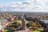 Luftaufnahme eines historischen Turms in einem Stadtzentrum mit umliegenden Parks und Gebäuden.
