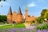 Holstentor in Lübeck mit Blumen und Personen im Vordergrund.